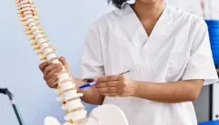 Especialista con un modelo anatómico de columna